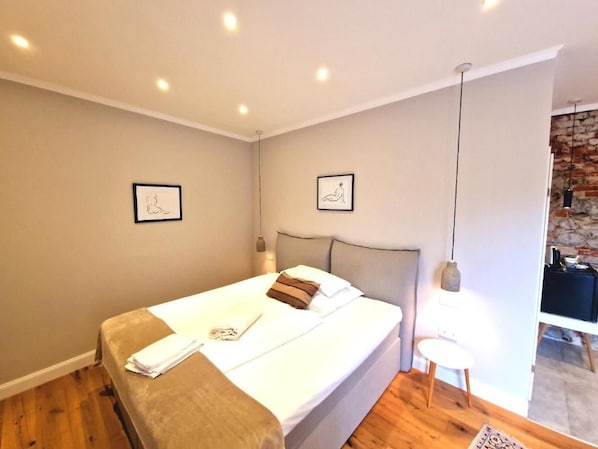 A modern bedroom with a large bed, two bedside tables, and a hanging light fixture. - Gutshaus beim Zeilinger Schlössl (Knittelfeld)