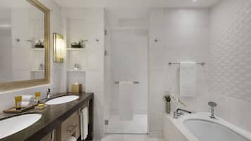 A modern bathroom with two sinks, a large mirror, a shower, and a bathtub.