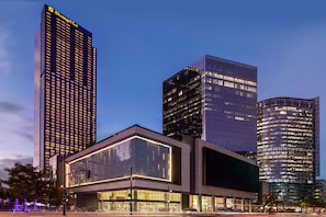 Un edificio moderno de gran altura con ventanas iluminadas y un cartel llamativo en la parte superior.