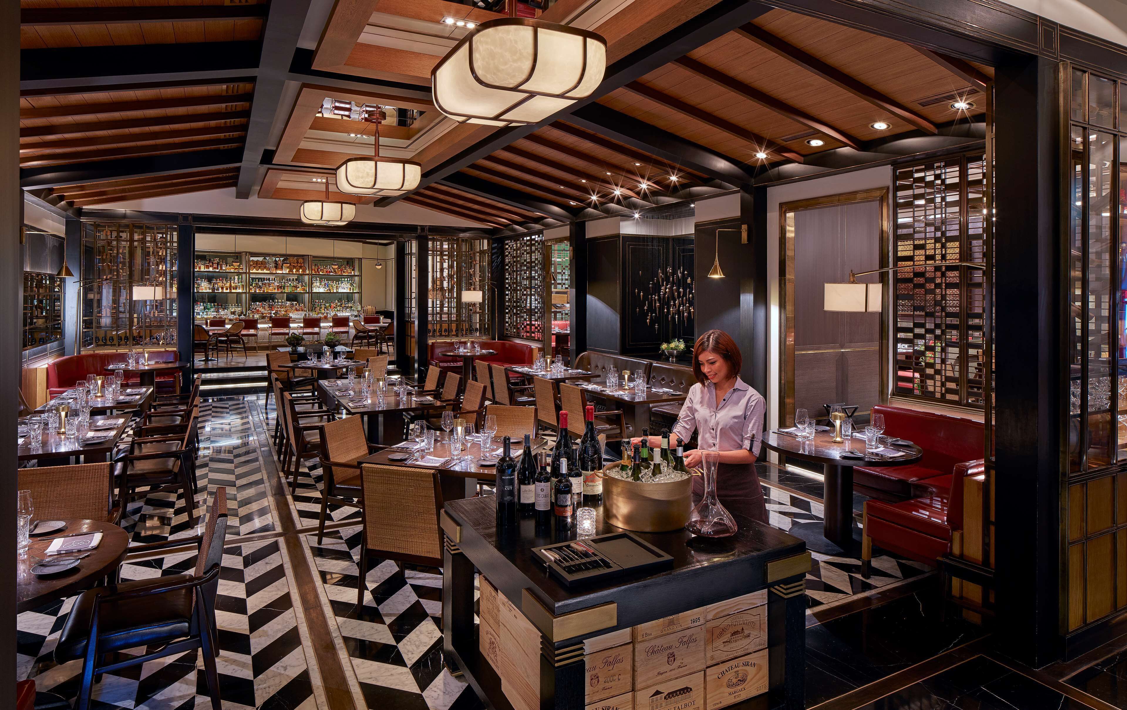 A restaurant with a bar area, wooden ceiling, and checkered floor.