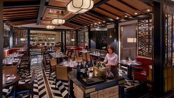 A restaurant with a bar area, wooden ceiling, and checkered floor.