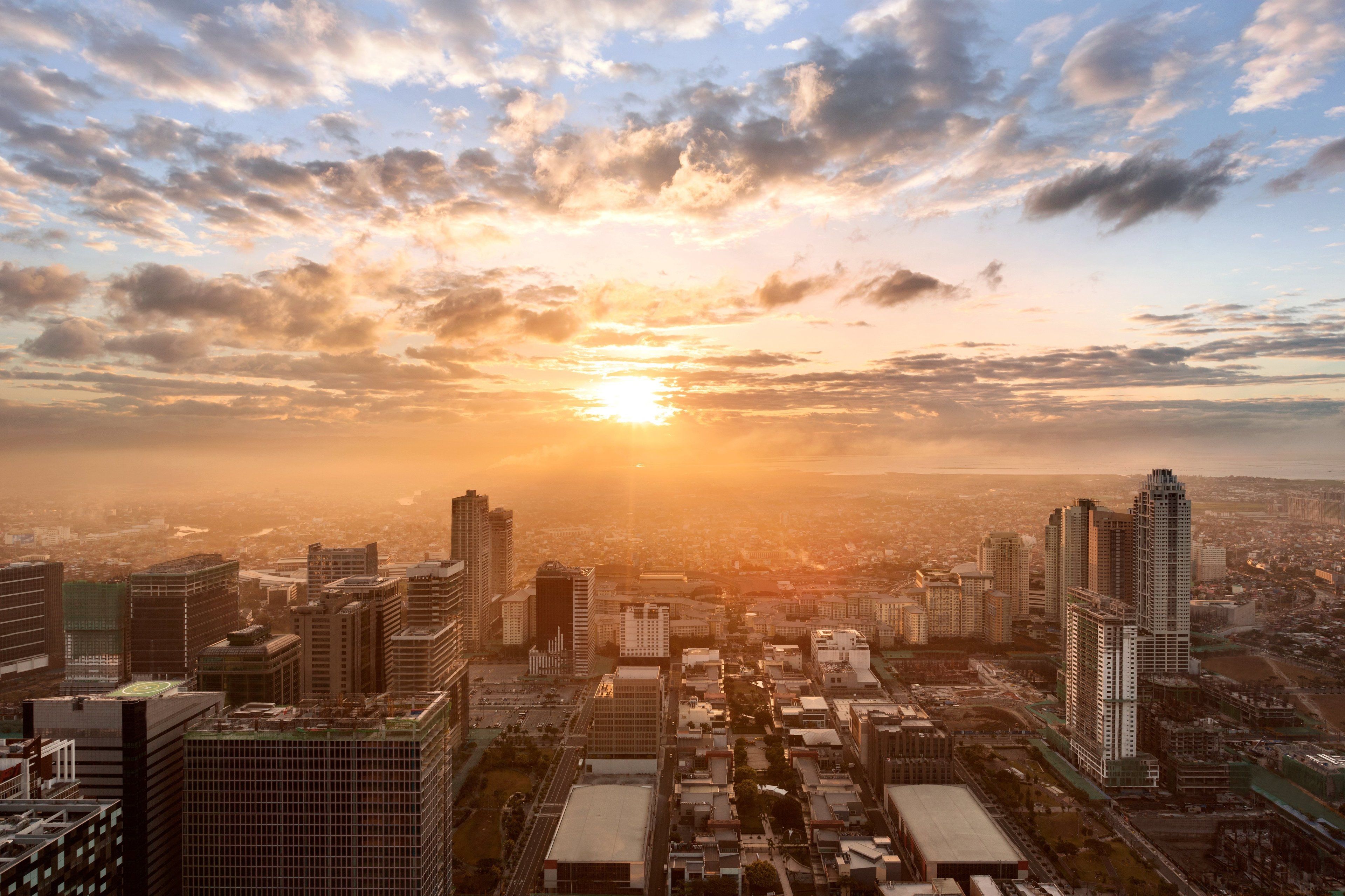 A cityscape with high-rise buildings and a sunset.