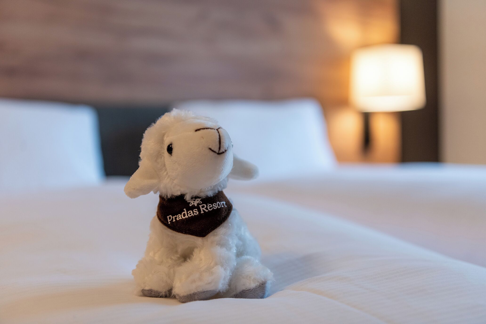 Un peluche con una etiqueta sobre una cama.