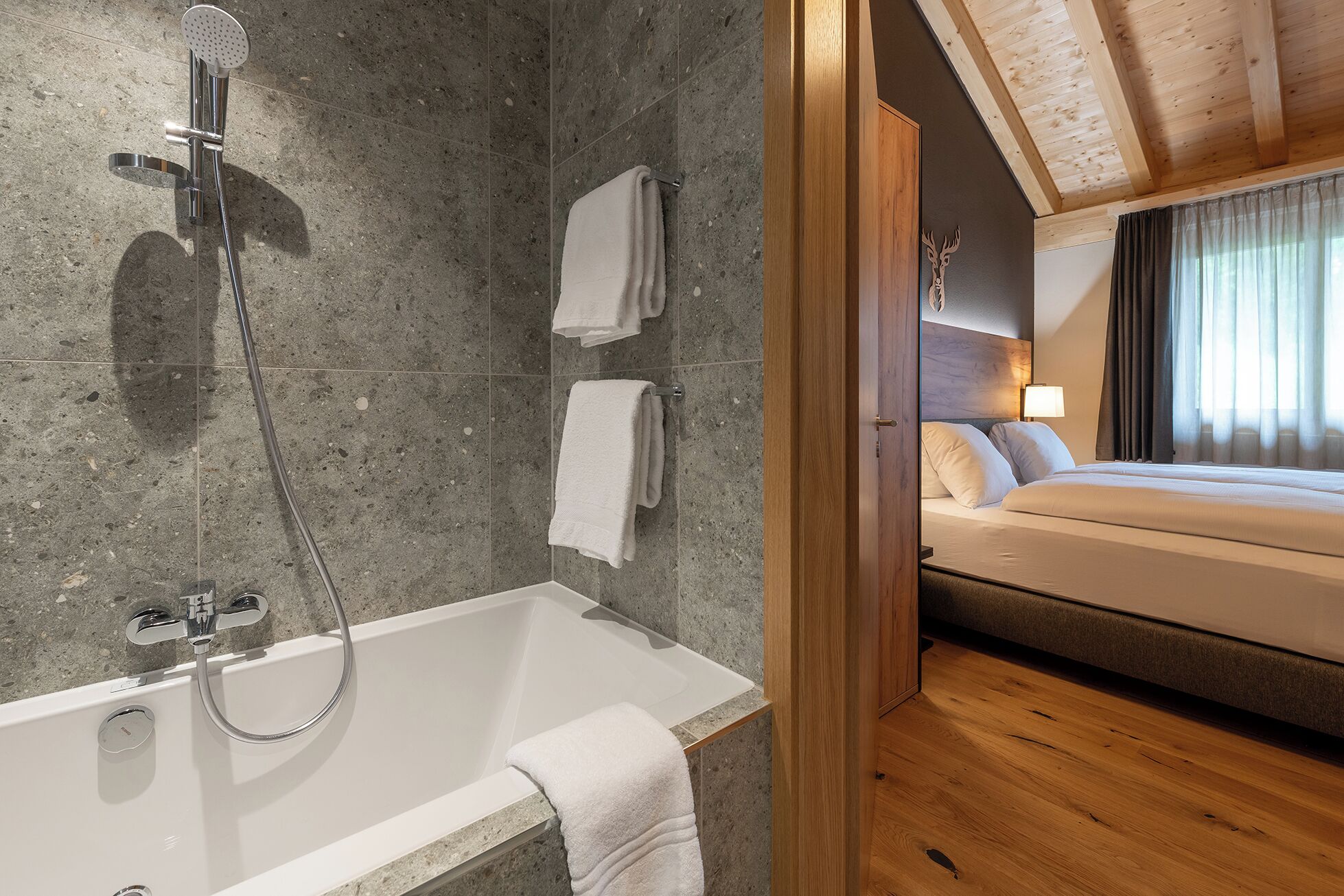 Une salle de bain moderne avec une baignoire et une douche, des murs carrelés et un plafond en bois.