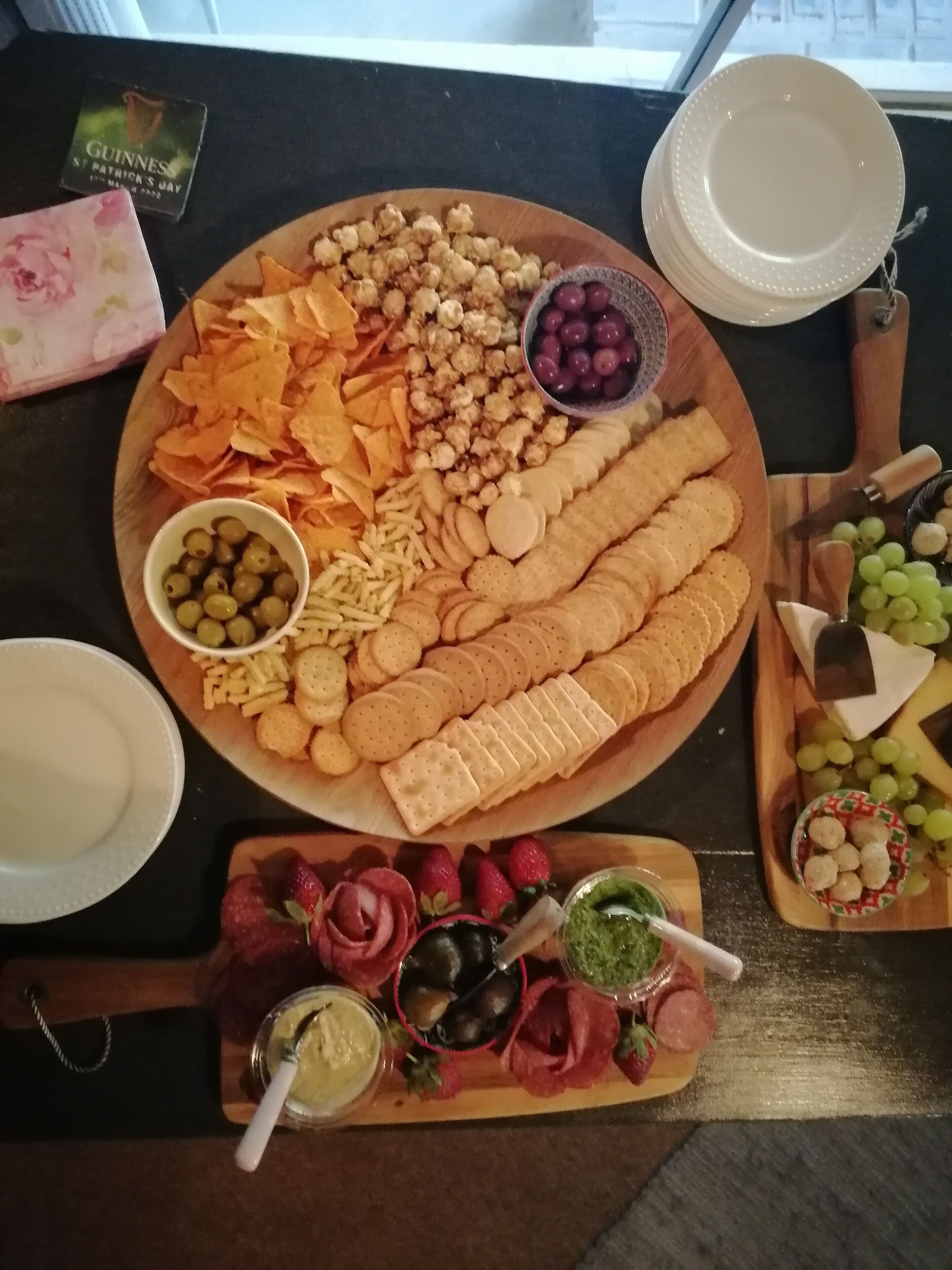 A table with a variety of snacks and appetizers, including chips, crackers, olives, and cheese.