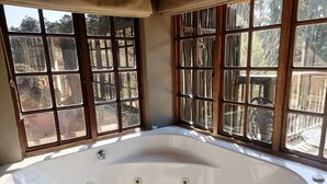 A large, oval-shaped bathtub with a white interior and a small towel placed on the edge. - Hawklee Country House (Fort Nottingham)