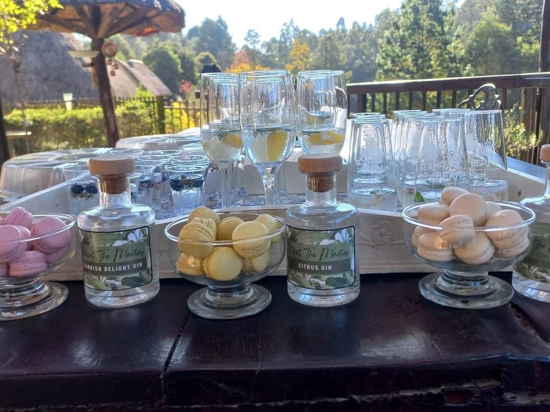 Una mesa con varios vasos, recipientes de lokum y ginebra.