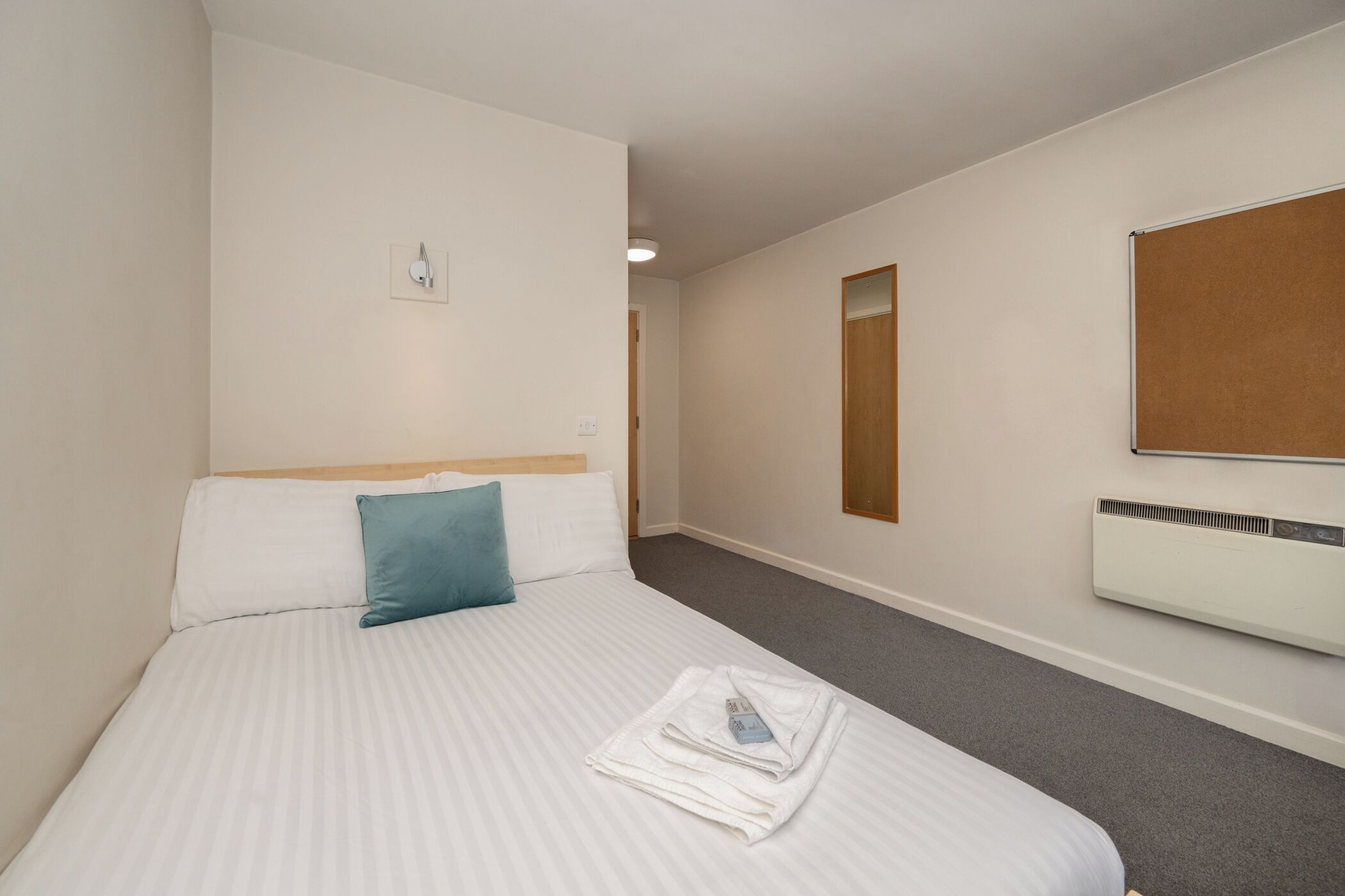 Cubrecamas, escritorio y espacio para trabajar con laptop 