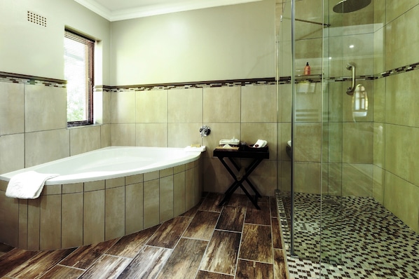 A bathroom with a freestanding bathtub, a glass-enclosed shower, and a tiled floor.