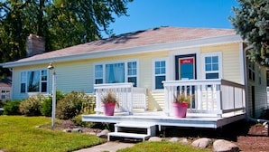 A yellow house with a front porch, a chimney, and a sign that says "office". - Blue Door Cottages (Monticello)