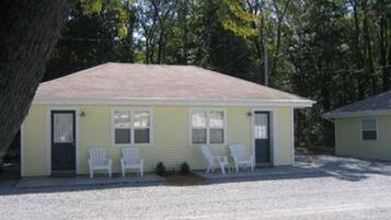 Un motel d’un seul étage, au design simple et fonctionnel. Il est doté d’un petit porche avec deux chaises en plastique blanches et d’un petit marchepied menant à l’entrée. Le bâtiment a un toit plat et une seule porte de garage.