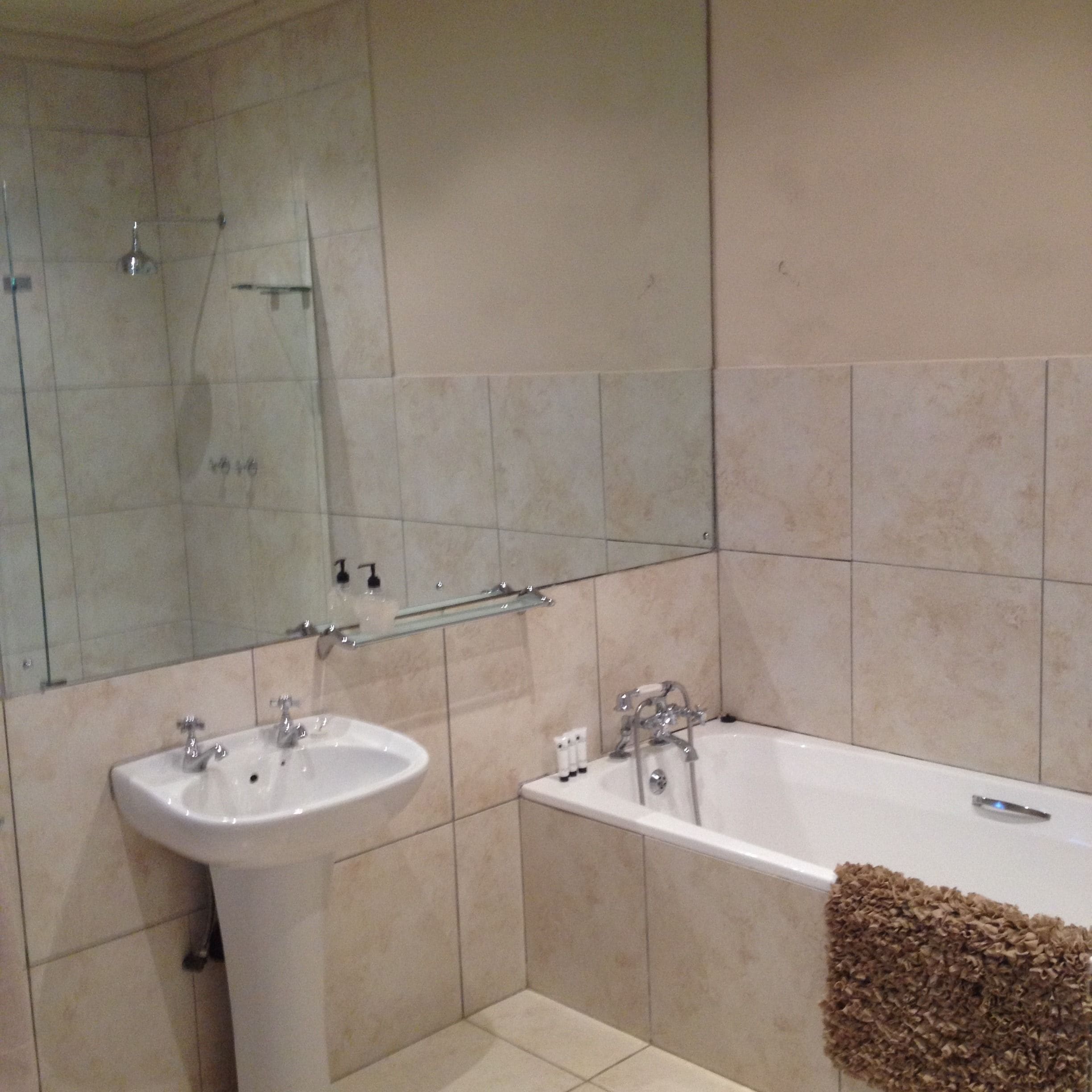 A bathroom with a sink, a bathtub, and a glass shower enclosure.