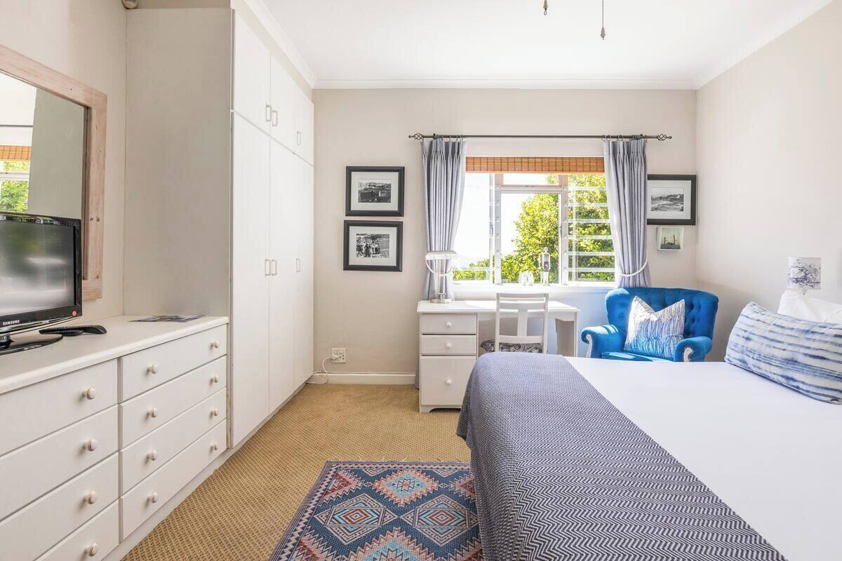 Ein Schlafzimmer mit Bett, Schreibtisch, Stuhl und Fernseher.