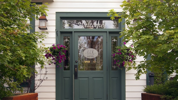 A green double door with a 'Welcome' sign and a 'The Historic Elk Mountain Hotel' sign. - The Historic Elk Mountain Hotel (Elk Mountain)
