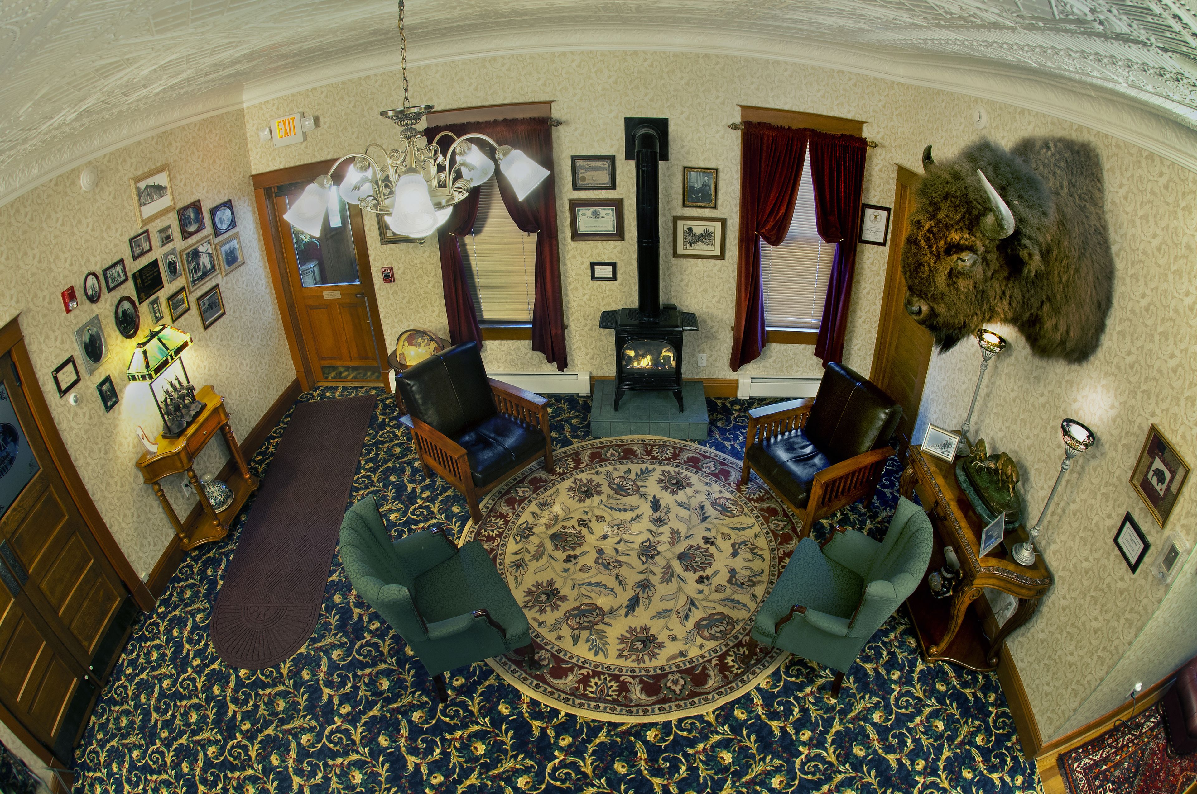 A traditional room with a fireplace, patterned carpet, and classic furniture.