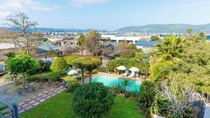 Ein Wohngebiet mit Schwimmbad, Gartenmöbeln und üppiger Bepflanzung.