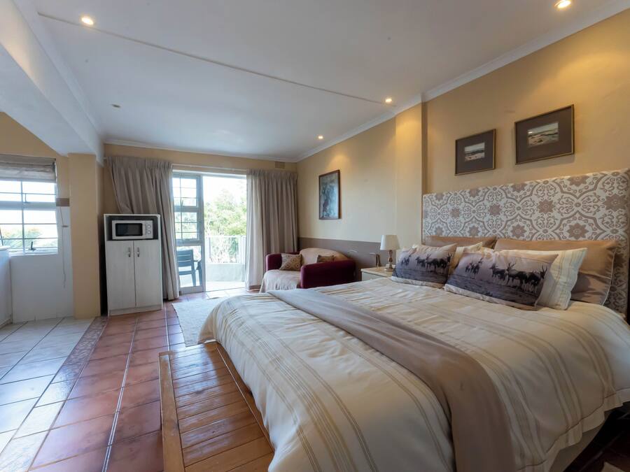 Un dormitorio con una cama grande, un televisor y una puerta corrediza al balcón.