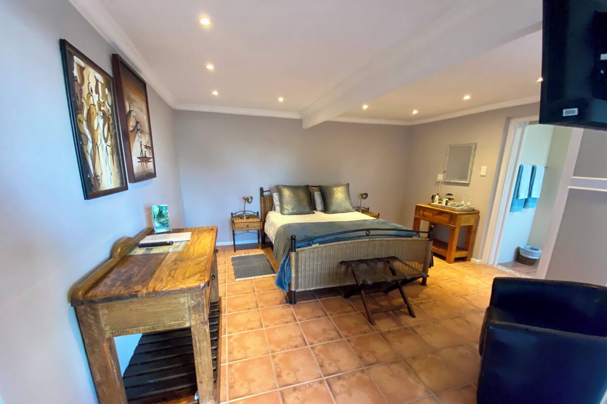 A bedroom with a bed, bedside table, and a chair.