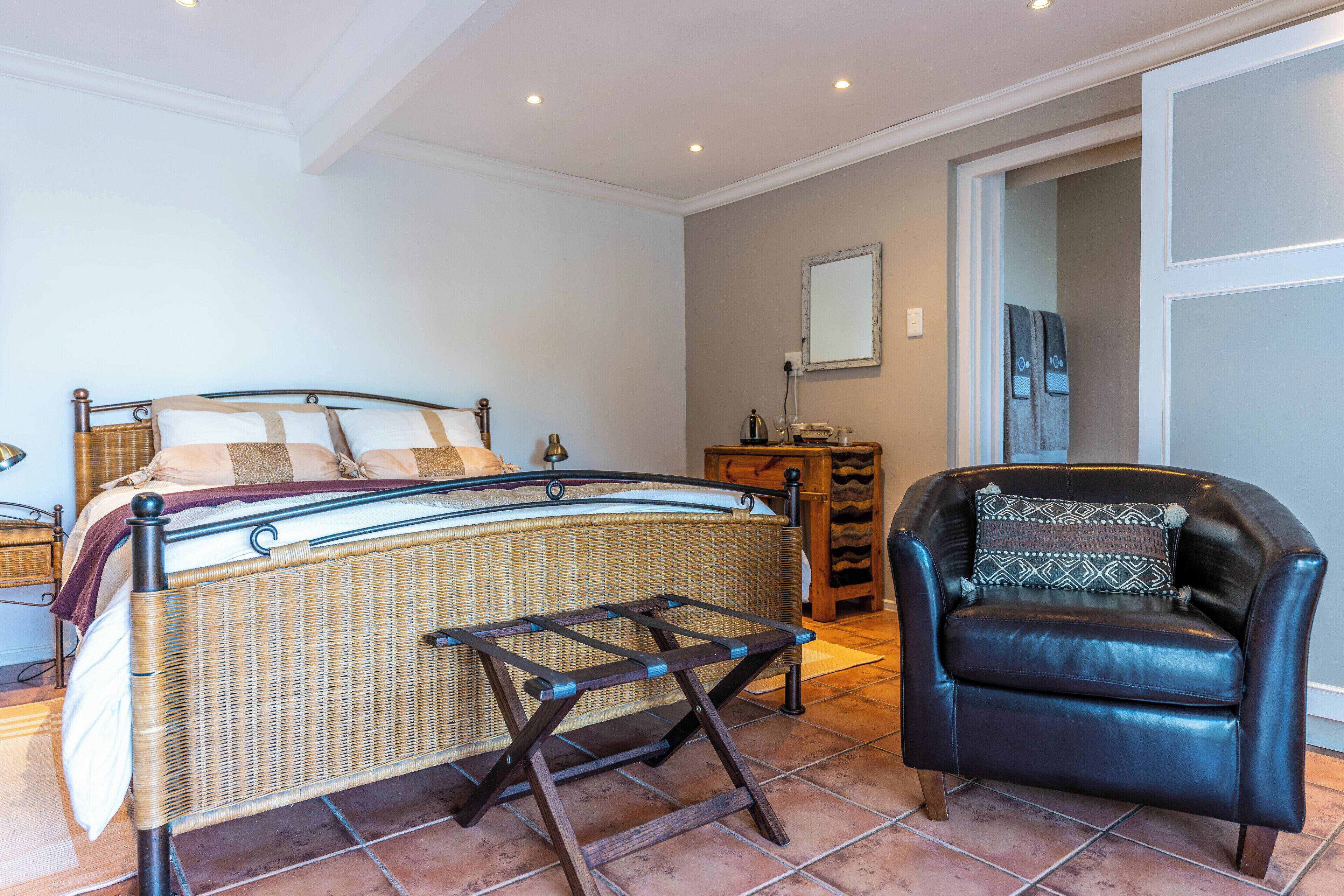 A bedroom with a bed, a chair, and a small table.