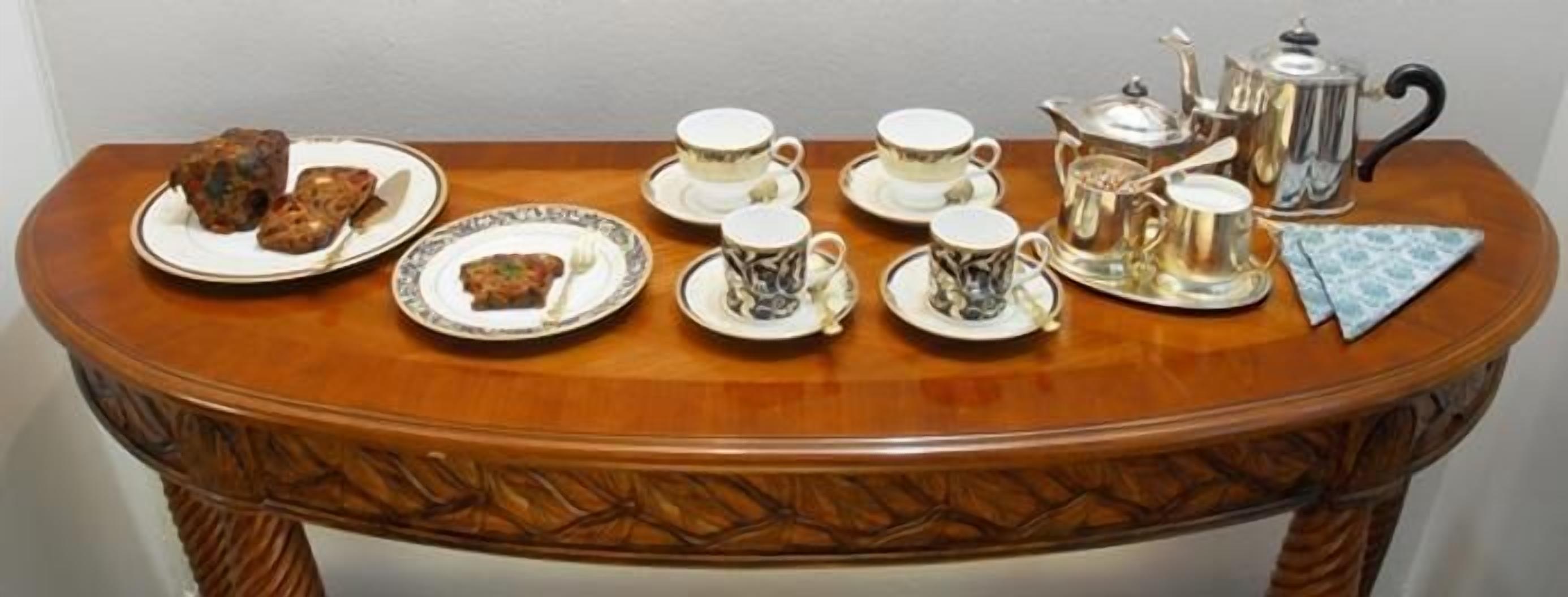 A table set with tea service, including cups, saucers, and a teapot.