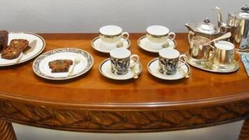 A table set with tea service, including cups, saucers, and a teapot.