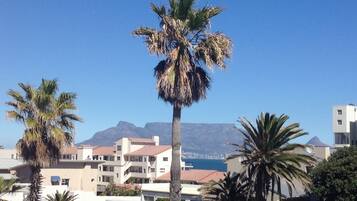 A coastal building with a view of the sea and mountains.