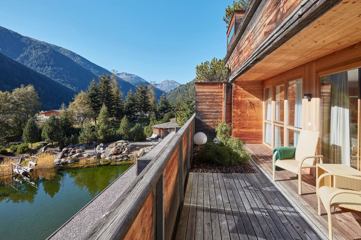 A wooden deck with a view of a lake and mountains.