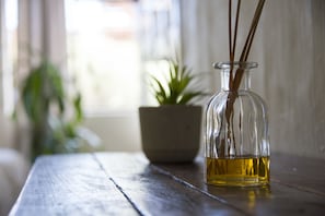 A clear glass bottle with a plant inside, placed on a wooden surface.
