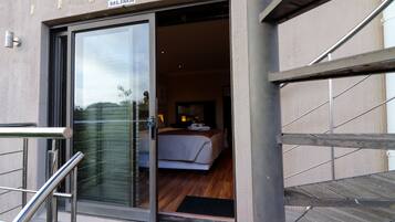 Una habitación de hotel con cama, ventana y puerta que da al exterior.
