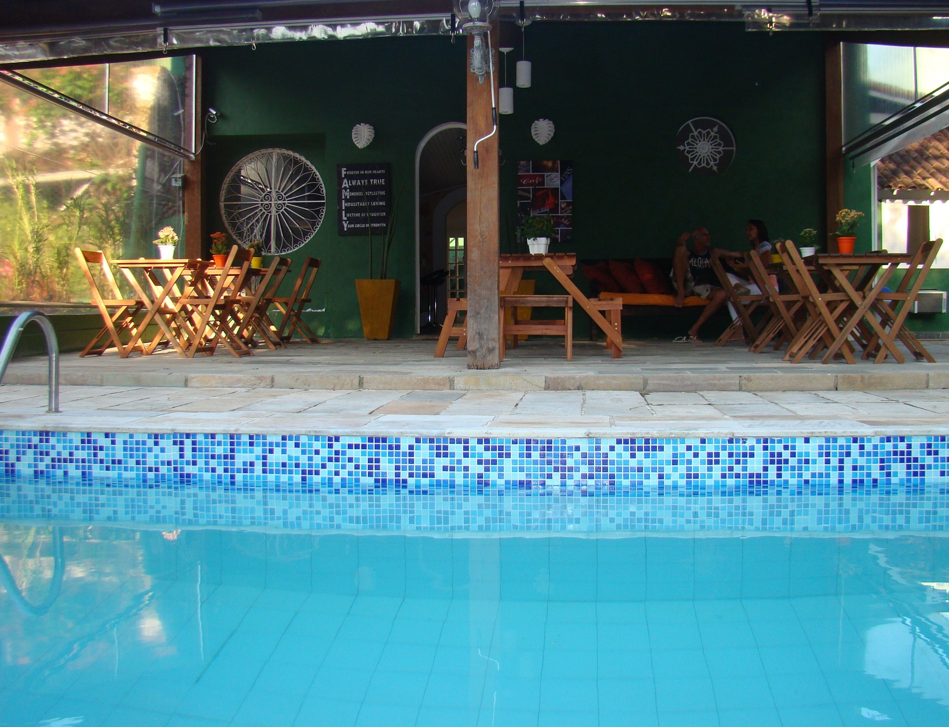 A poolside area with lounge chairs and a sign with inspirational quotes.