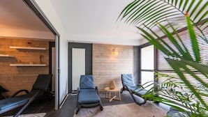 A modern room with a sliding glass door, a wooden wall, and a large window with blinds. - Résidence Odalys Fleur de Sel (Guidel)
