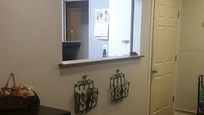 A hallway with a sign reading "ROYAL INN" above a window. There are two decorative metal baskets on the wall below the window.
