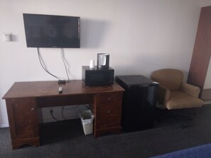 Escritorio, cortinas blackout y tabla de planchar con plancha