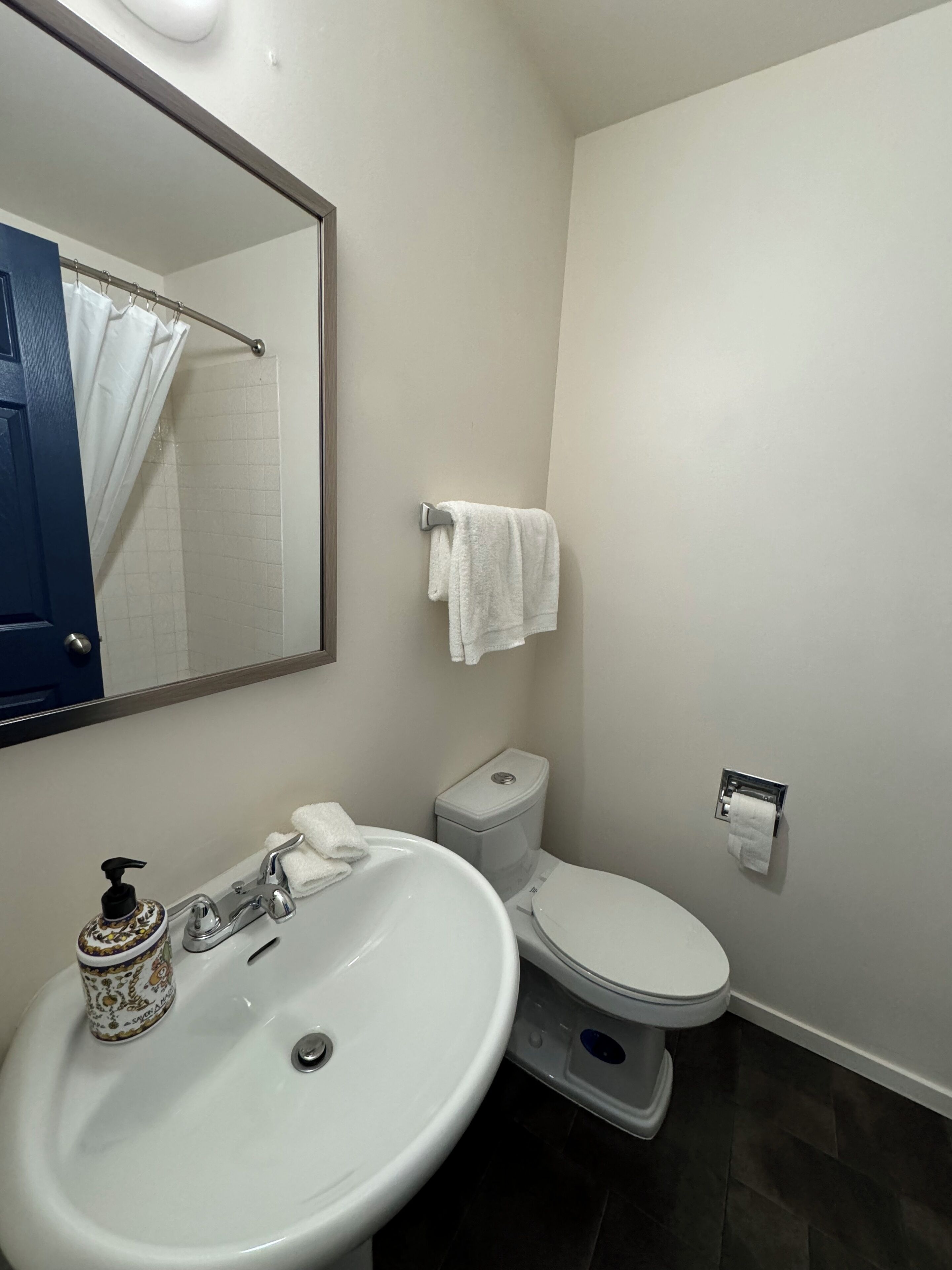 A bathroom with a white sink, a toilet, and a shower curtain.