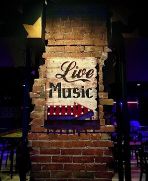 Un muro de ladrillo con un cartel que dice 'Live Music'.