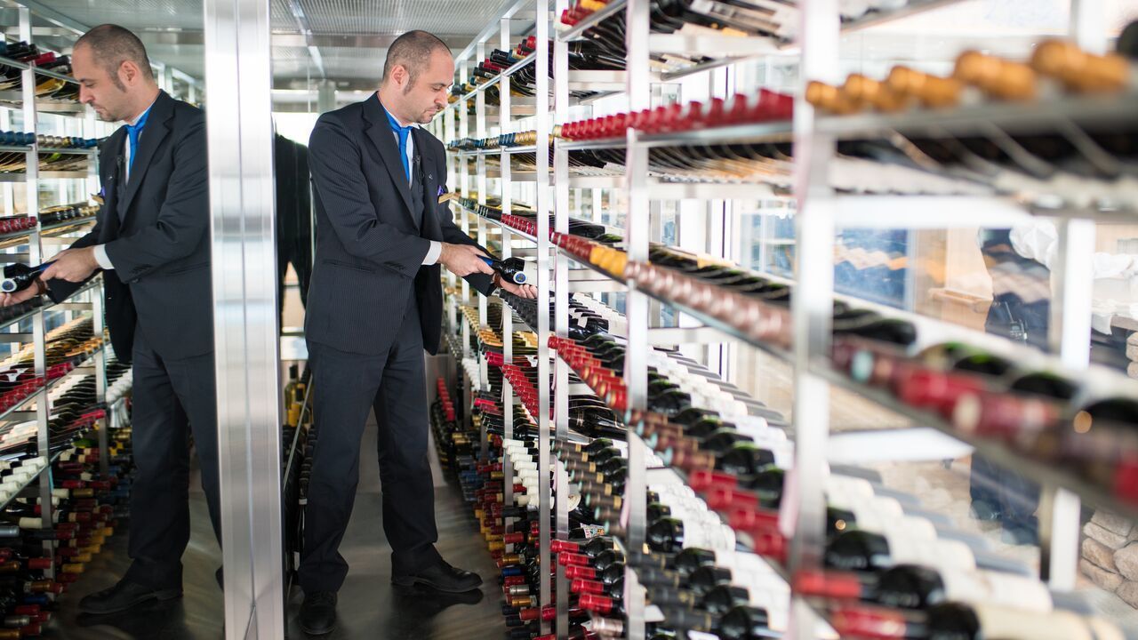 A wine cellar with shelves stocked with wine bottles.