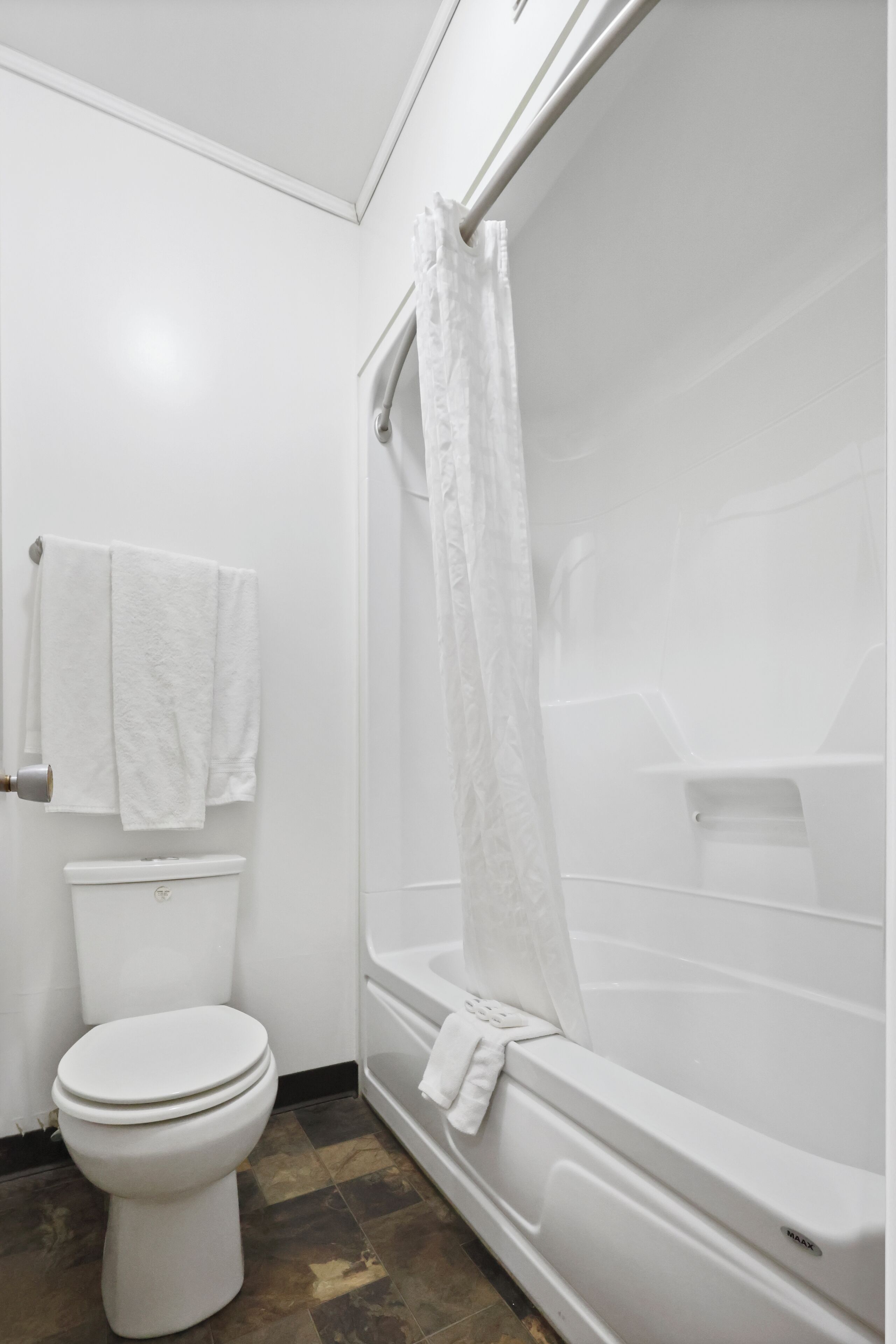 A bathroom with a toilet, a bathtub, and a shower curtain.