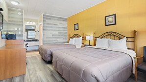 A hotel room with two beds, a wooden desk, a mirror, and a bathroom visible through an open door. - Dauphin Inn Express (Dauphin)