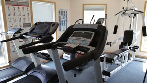 A gym with treadmills, a stationary bike, and weight machines. - Athabasca Lodge Motel (Athabasca)