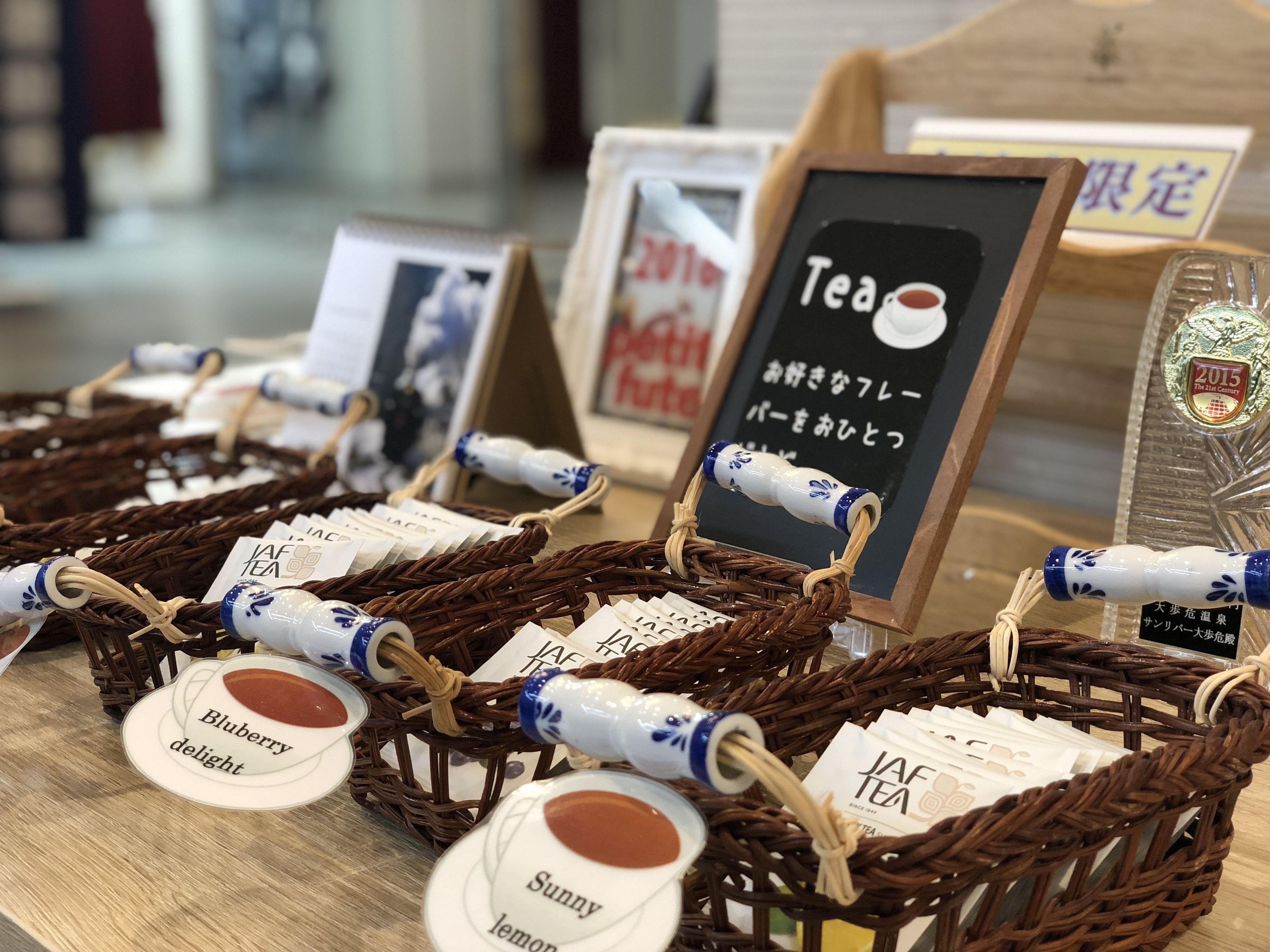 A display of tea sets with labels indicating different flavors like blueberry delight and sunny lemon.