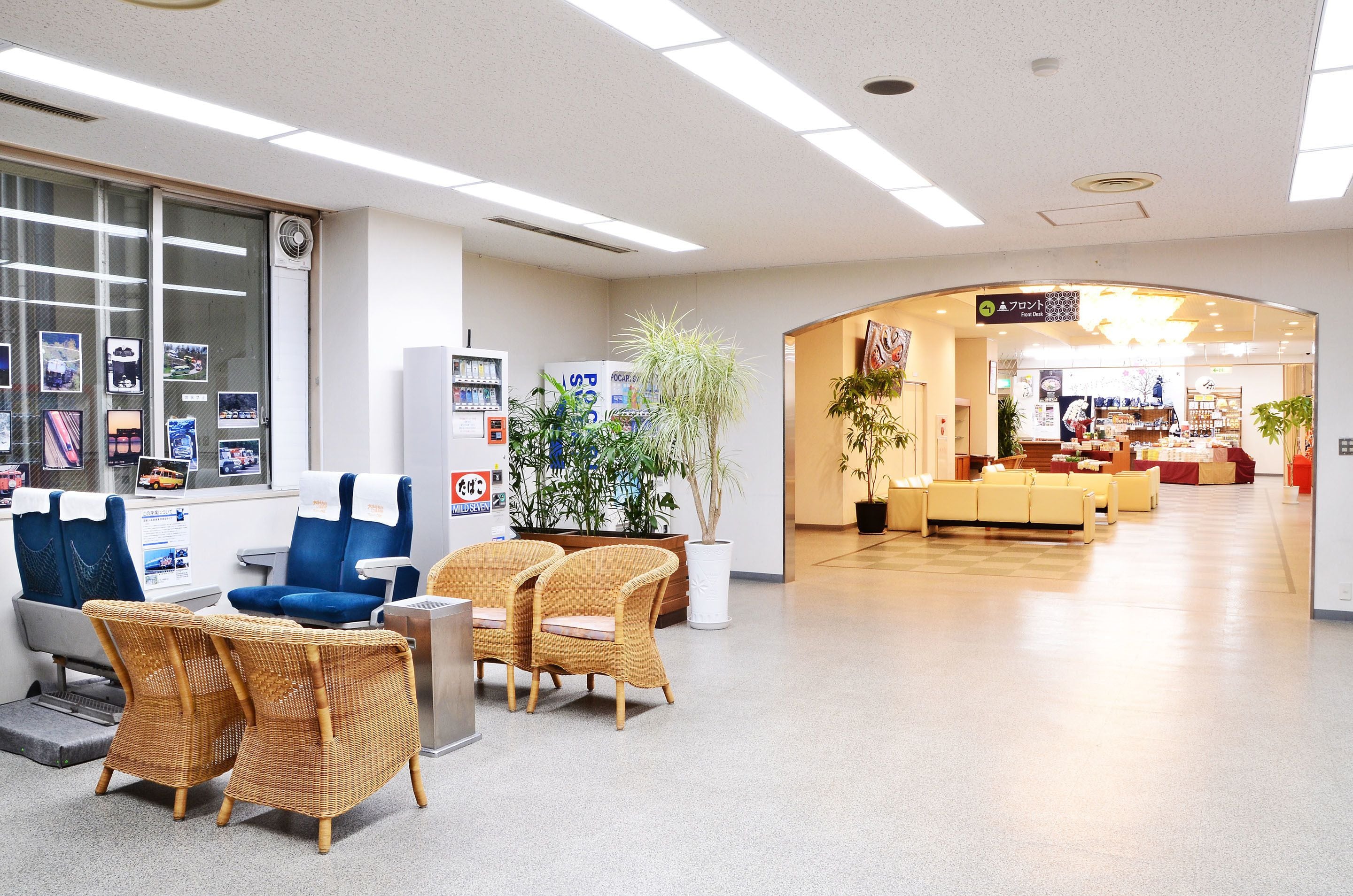 A reception area with a counter, seating, and a plant.
