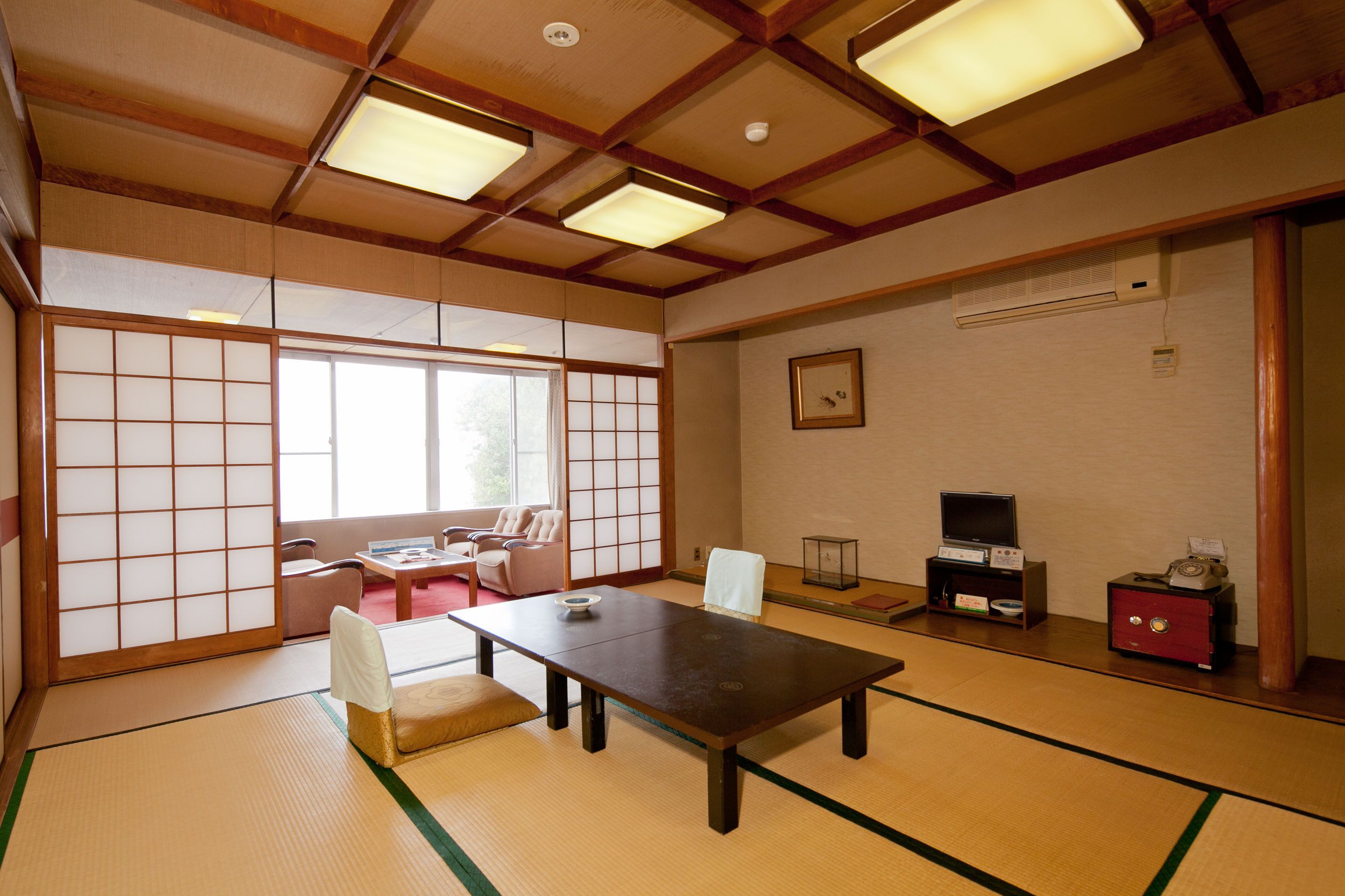 A traditional Japanese room with tatami flooring, a low table, and sliding doors.