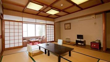 A traditional Japanese room with tatami flooring, a low table, and sliding doors.