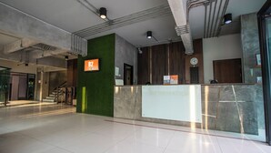 Un espace d’accueil moderne agrémenté d’un mur végétal, d’une horloge et d’un panneau indiquant la salle B2.