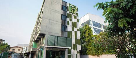 Un edificio moderno con facciata verde e bianca, ampie finestre e un ingresso ben visibile.