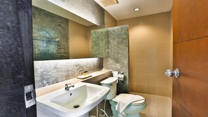 Un baño moderno con un espejo grande, un lavabo, un inodoro y una zona de ducha.