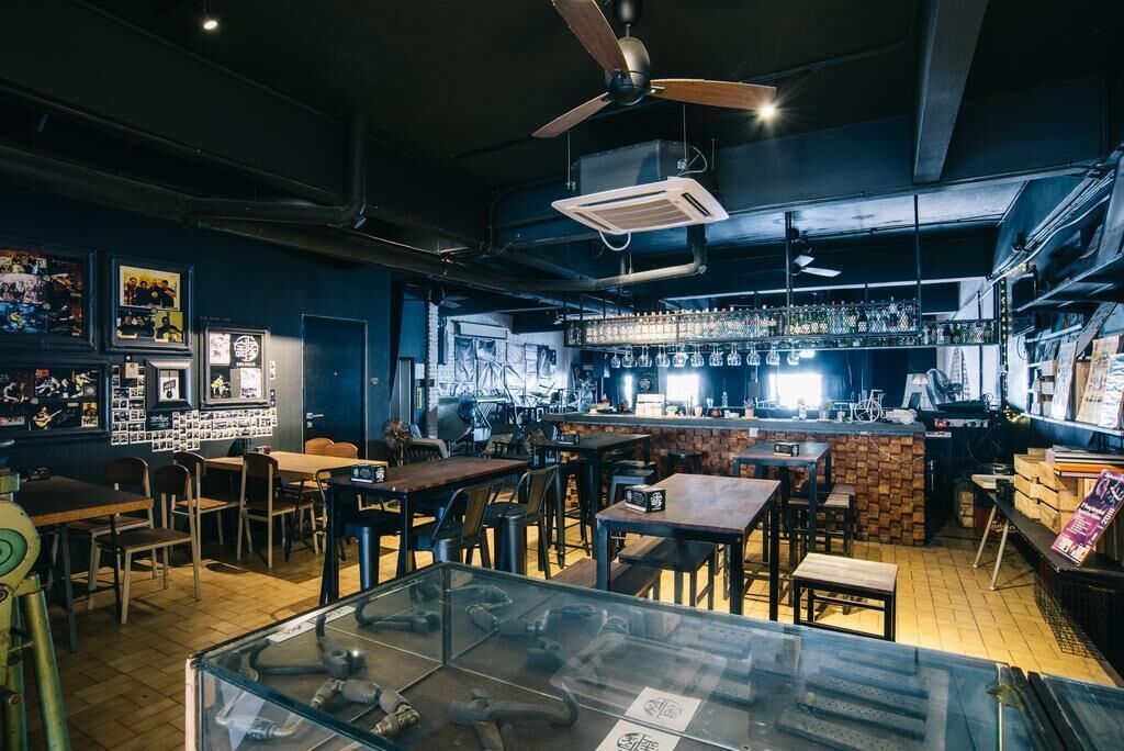 A bar area with tables, chairs, and a counter with a barista.