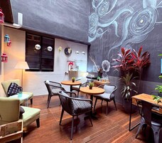 Un área de estar interior acogedora con un mural, suelo de madera y muebles modernos.