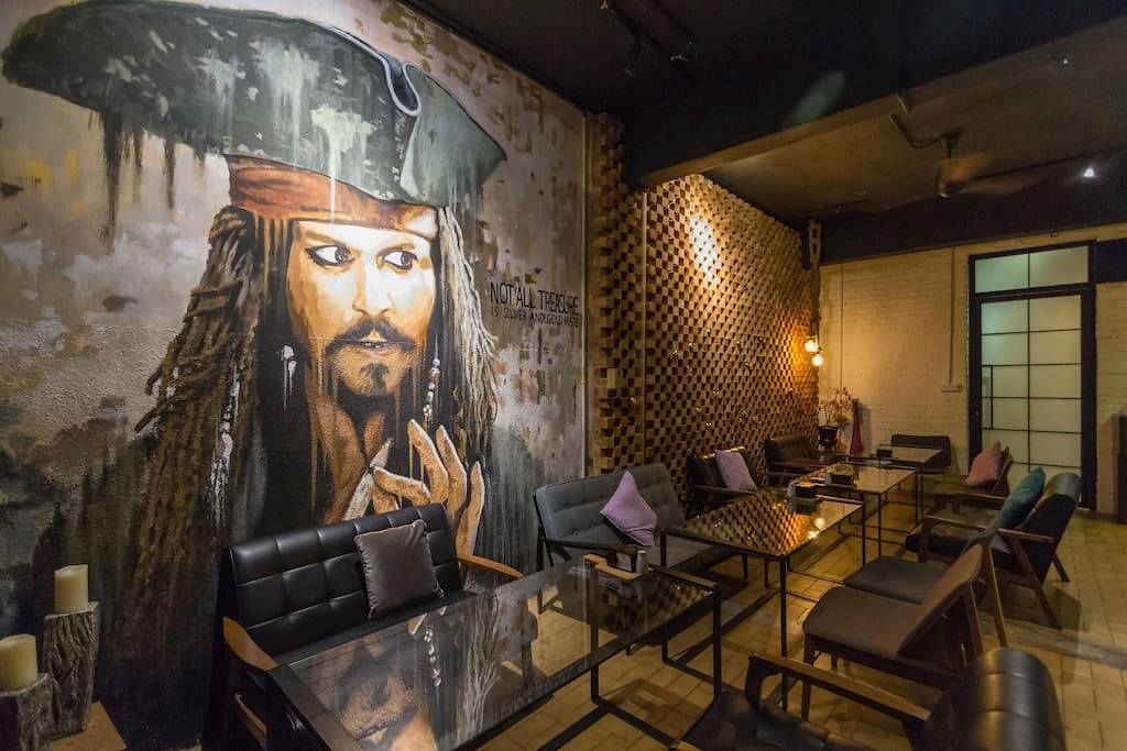 A modern lounge with a mural, leather seating, and a patterned wall.