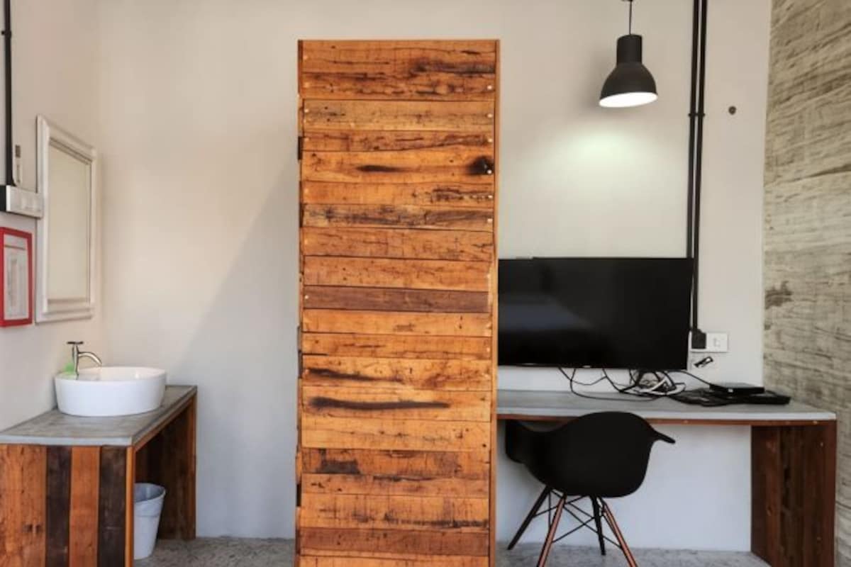 Un baño moderno con una pared de acento de madera, un lavamanos y una silla.